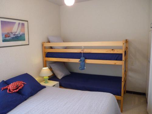 - une chambre avec 2 lits superposés et des draps bleus dans l'établissement Sol-y-Days Yucca, Agreable appartement en RDC avec petite terrasse et parking à 150m de la plage, au Grau-du-Roi