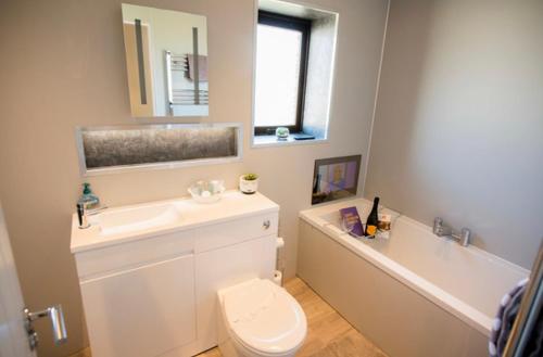 a bathroom with a sink and a toilet and a tub at Annie's Corner - Fort William in Caol