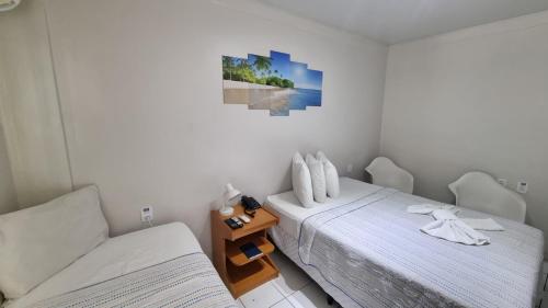a bedroom with two beds and a picture on the wall at Hotel Ponta Negra Beach by Oxequealuguel in Natal
