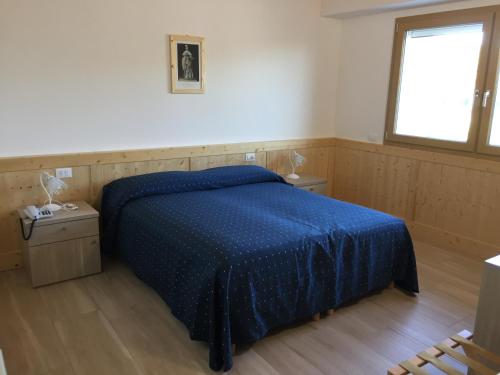 ein Schlafzimmer mit einem blauen Bett und einem Fenster in der Unterkunft SAN FERDINANDO in Levada