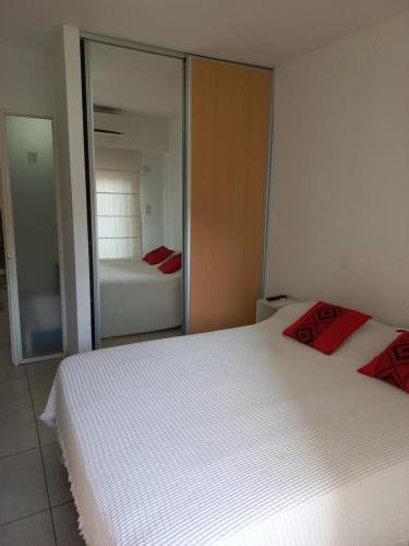 a bedroom with two white beds and a mirror at Mendoza 2138 Apartamento in Rosario
