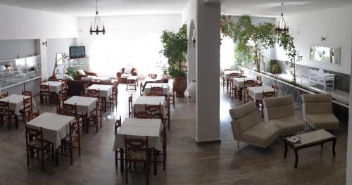 a restaurant with tables and chairs in a room at Porto Castello in Fira