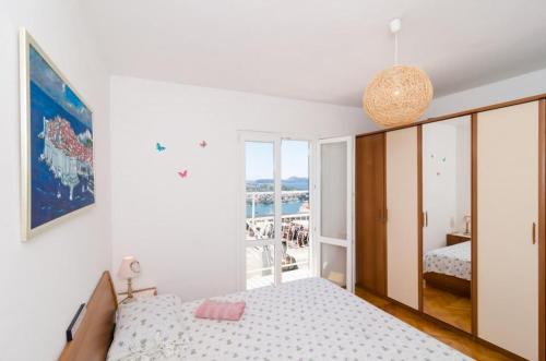 a white bedroom with a bed and a balcony at Ivo Guest House in Dubrovnik