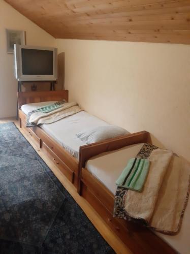a small bedroom with a bed and a television at Relax house in Visoko