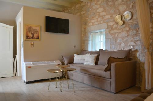 a living room with a couch and a stone wall at Olea in Pirgos Dhirou