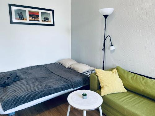 ein Schlafzimmer mit einem Bett, einem Sofa und einem Tisch in der Unterkunft Luxodonta Apartment in Krakau