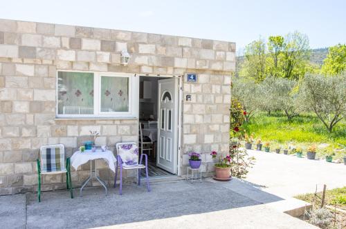 una casa in pietra con tavolo e sedie all'esterno di Apartments Good Vibrations a Rožat