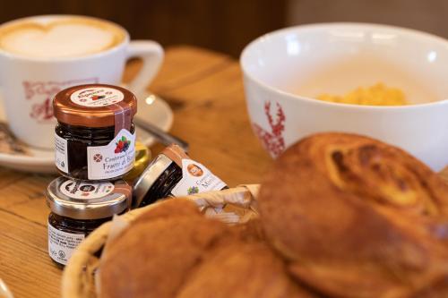 a table with two cups of coffee and some bread at La Cascata Chambres d'hôtes in La Salle