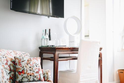 a living room with a chair and a table with a mirror at Boutiquehotel Kloster Pfalzel in Trier