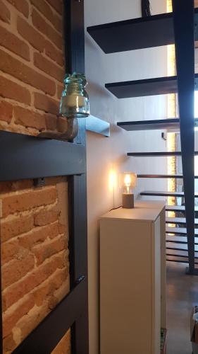 einen weißen Kühlschrank in einem Zimmer mit Ziegelwand in der Unterkunft Loft Mariola - Apartamento en el centro histórico in Bocairent