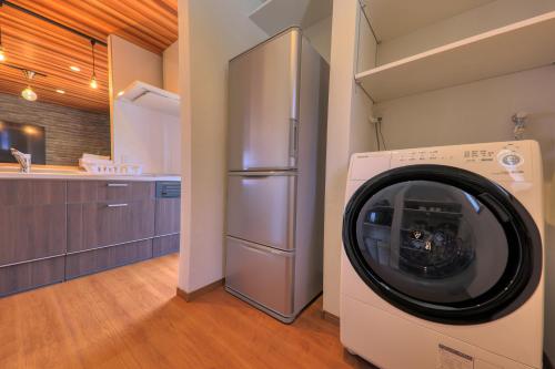 a washing machine in a kitchen with a refrigerator at Glamping Cottage Kawaguchiko in Fujikawaguchiko