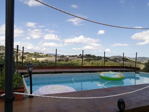 a pool with a view of the rolling hills at La Cascina di Muttley in Doglio