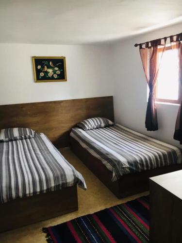 a bedroom with two beds and a window at Вила Вълнара in Sredets