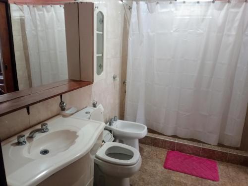 a bathroom with a white toilet and a sink at Casa a 5 km de Villa de Las Rosas in Las Tapias