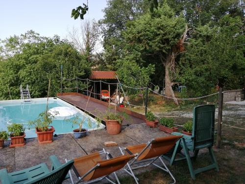 a backyard with a pool with chairs and a fence at La Cascina di Muttley in Doglio
