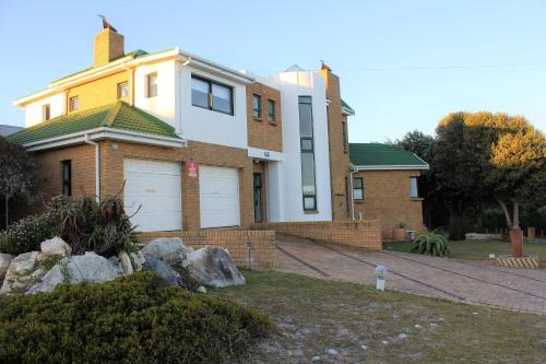 a large brick house with a white garage at The Sun Catcher Bed & Breakfast in Struisbaai