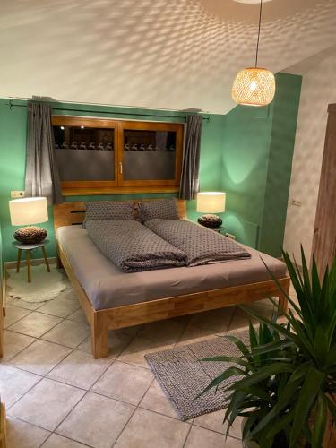 a bed in a room with a green wall at Sepps Appartement in Fieberbrunn