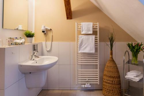 a white bathroom with a sink and a mirror at Wohnen am Schloss, Schlossblick in Sondershausen