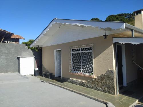 una pequeña casa con una ventana y una puerta en Casa aconchegante com lareira en Campos do Jordão