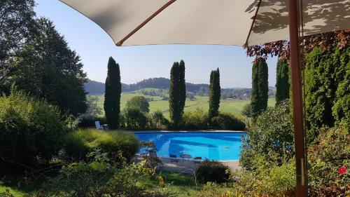 a view of a swimming pool in a garden with trees at Humboldt-Haus in Achberg