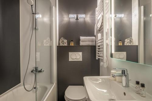 y baño con aseo, lavabo y ducha. en The Originals City, Angers Sud, Le Village 49, en Les Ponts-de-Cé