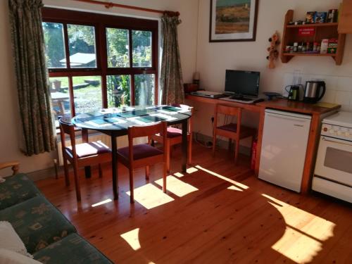 cocina con mesa y sillas y cocina con ventana en Lovely Sea View Apartment in Rineen - 4 guests, en Skibbereen