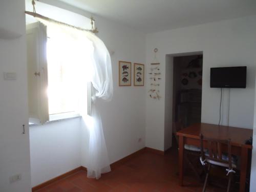 a room with a window and a desk and a television at Voglia di mare in Capraia