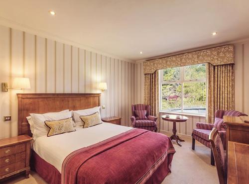 a hotel room with a bed and a window at Lakeside Hotel and Spa in Newby Bridge