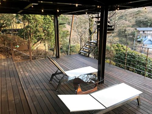 a wooden deck with two white benches on it at VILLA HAKONE湖空 in Hakone