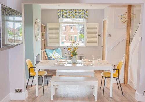 a dining room with a white table and chairs at Modern 3-Bed House on Tarporley High Street in Tarporley