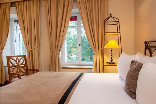 a bedroom with a bed and a window at Hotel de la Cité Carcassonne - MGallery Collection in Carcassonne