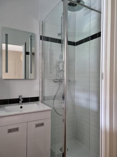 a bathroom with a glass shower and a sink at Le Prevet in Saint Malo