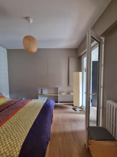 - une chambre avec un lit et une porte coulissante en verre dans l'établissement Le Prevet, à Saint-Malo