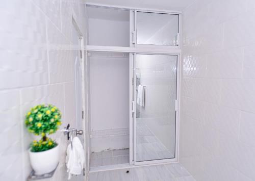 y baño con ducha y puerta de cristal. en Acogedora casa en Punta Cana Amueblada, en Punta Cana