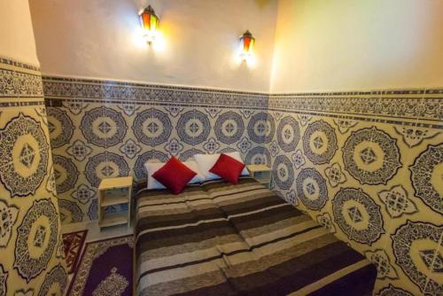 a bedroom with a bed with red and white pillows at Dar Zin in Fez