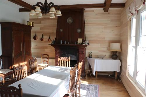 a dining room with a table and a fireplace at Les Gouleries in Dangy