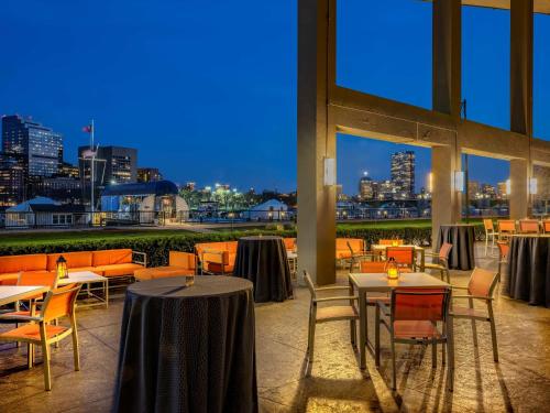 a restaurant with tables and chairs and a view of the city at The Royal Sonesta Boston in Cambridge