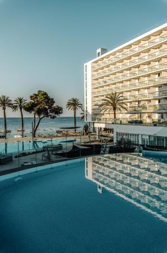 a hotel with a swimming pool next to a beach at The Ibiza Twiins - 4* Sup in Playa d'en Bossa