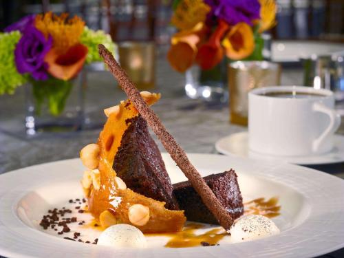 a piece of cake on a plate with a cup of coffee at The Royal Sonesta Boston in Cambridge