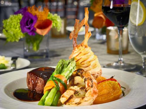 a plate of food with shrimp and vegetables on a table at The Royal Sonesta Boston in Cambridge