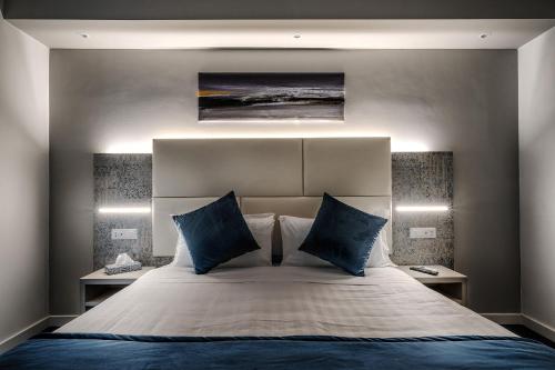 a bedroom with a large bed with blue pillows at Suite Blue Style in Rome
