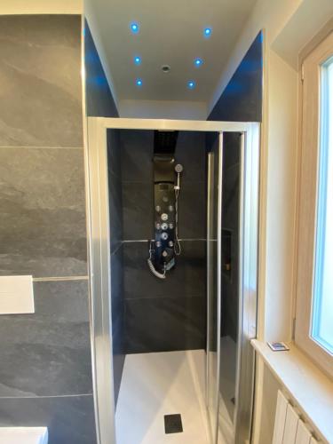 a walk in shower with a glass door in a bathroom at Relaxing Home in Tignale