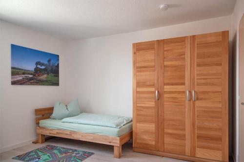 Cette chambre comprend une armoire en bois et un lit. dans l'établissement Ferienwohnung-MAJA-in-Sassnitz-fuer-2-Erwachsene-und-1-Kind-oder-3-Erwachsene, à Sassnitz
