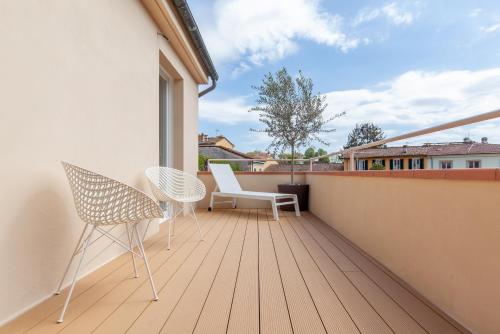 a balcony with two chairs and a window at Lunam Penthouse in centre in Lucca