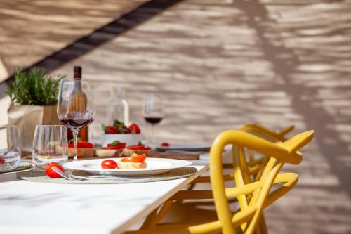 un tavolo con un piatto di bicchieri da cibo e vino di Lunam Penthouse in centre a Lucca