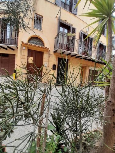 a building with balconies and a palm tree in front of it at La sinfonia di.kerkent in Agrigento