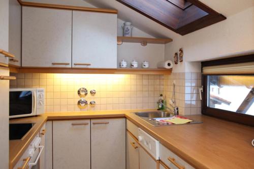 a kitchen with a sink and a microwave at Chaletwohnung Allgäutraum in ruhiger Lage von Burgberg unterhalb vom Grünten in Burgberg