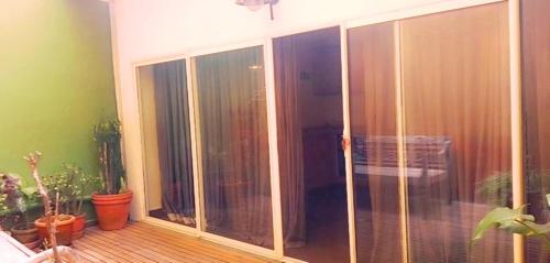 an empty balcony with sliding glass doors and plants at Hotel La Villette in Antananarivo