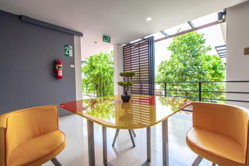 a dining room with a glass table and two chairs at Barista Hotel in Uttaradit