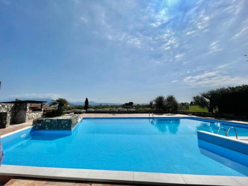 a large swimming pool with blue water at Garda Golf House in Soiano del Lago